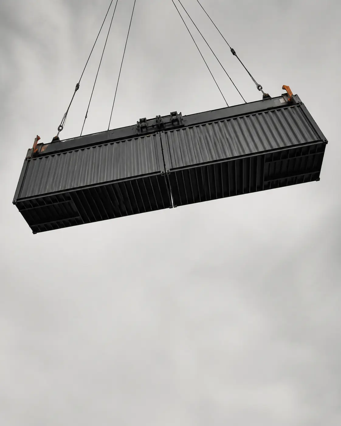 Shipping containers suspended mid-transfer by a terminal crane